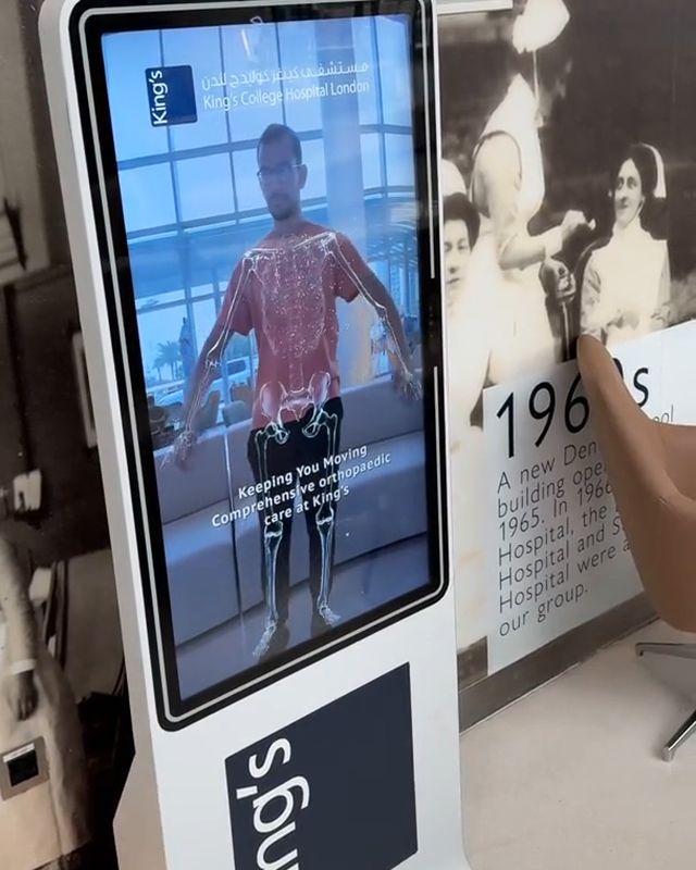 A guest sees himself in AR on a white FRXME display in the lobby of King’s College Hospital Dubai Hills.